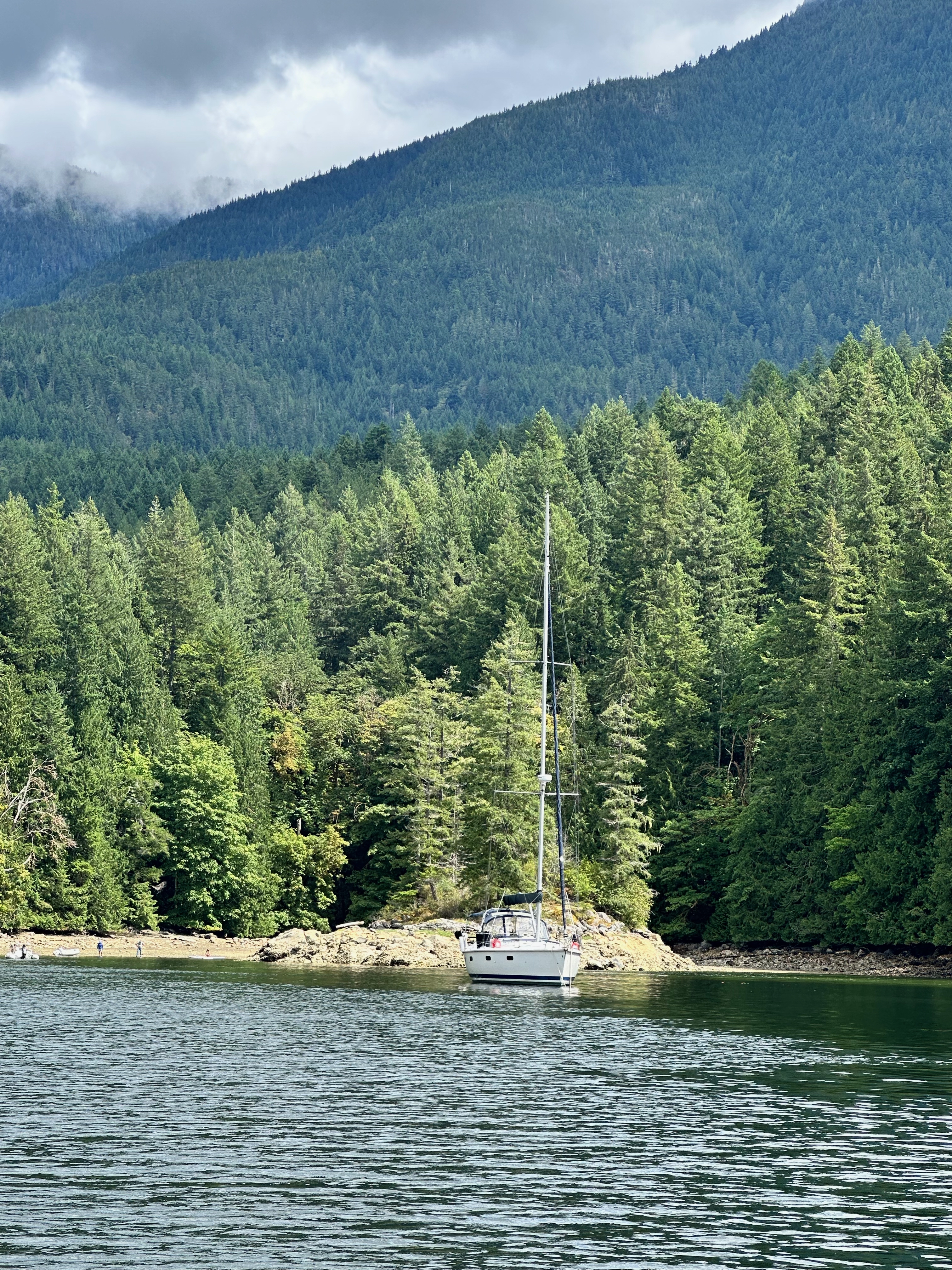 Oceanus anchored against the forested mountains of Melanie Cove