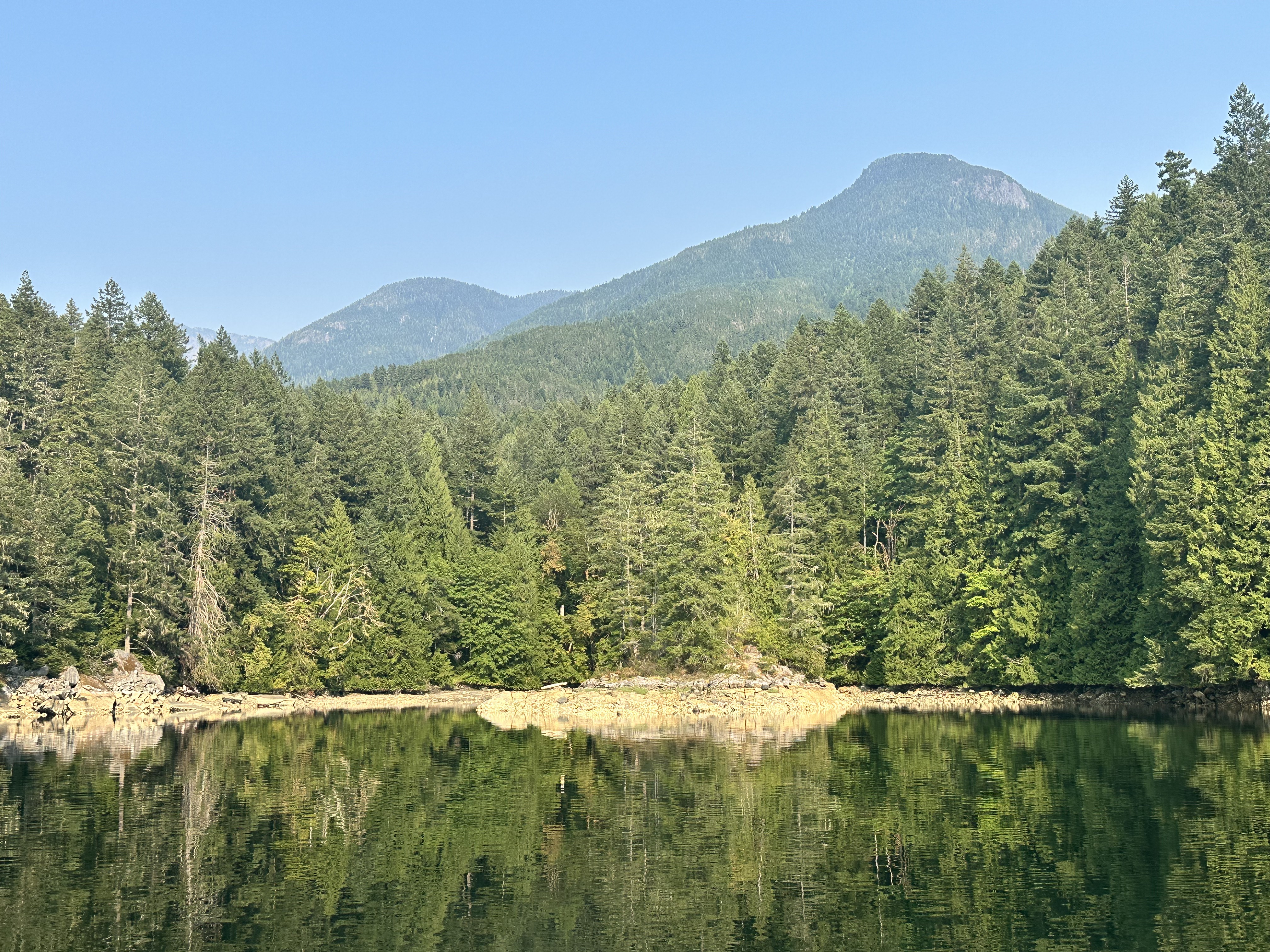 Boats anchored among rocky forested shores in Melanie Cove
